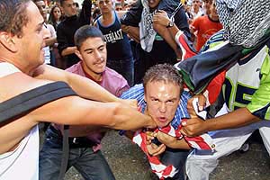 Anti-war protesters try to tear apart an American flag during a demonstration in Sydney 