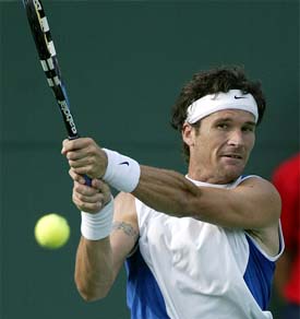 Carlos Moya of Spain hits a backhand to Robby Ginepri of USA 