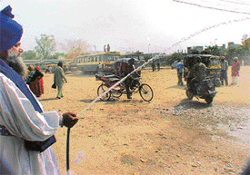 Jathedar Kulbir Singh, president of the Ludhiana Auto-Rickshaw Workers Federation, sprinkles water 