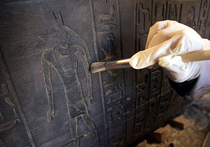 An Egyptian antiquities expert cleans a 3000-year-old sarcophagus