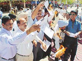 Members of the Chandigarh Beopar Mandal burn copies of VAT