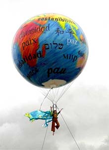 An actor flies hanging from a peace-globe
