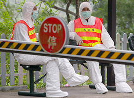 Security officers in protective suits to prevent themselves from catching the pneumonia-like severe acute respiratory syndrome 