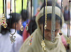 A devotee stands beside lockets with small idols of Hindu deities outside a temple