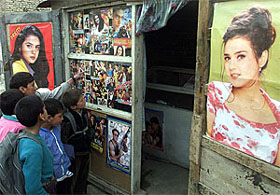 Afghan schoolchildren look at pirated video compact discs