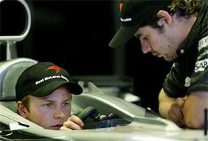 Finnish Formula One driver Kimi Raikkonen of the McLaren team speaks to a mechanic