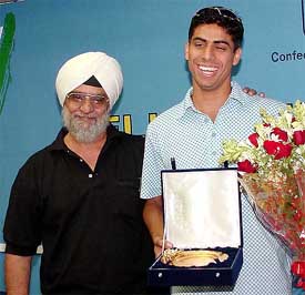 Ashish Nehra, a member of the World Cup team, laughs with former captain Bishan Singh Bedi during a felicitation function