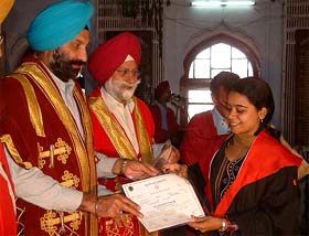 Mr Tarlochan Singh, Chairman, National Commission for Minorities, and Mr M. S. Dhillon, Principal, Khalsa College, present a degree to a student