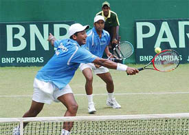 Mahesh Bhupathi fending off a volley from New Zealand's Mar Nielsen while Leander Paes looks on 