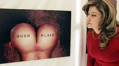 A Syrian artist looks at a painting symbolising what many Arabs see as blind backing by British Prime Minister Tony Blair of US President George W. Bush