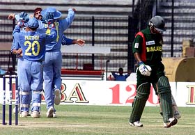 Indian wicket-keeper Parthiv Patel and skipper Virender Sehwag congratulate Sarandeep Singh after he dismissed Bangladeshi batsman Javed Omar 