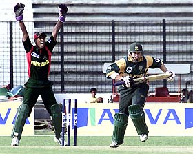 South African batsman Neil McKenzie takes a run as Bangladeshi wicket-keeper Mohammad Salim appeals for lbw 
