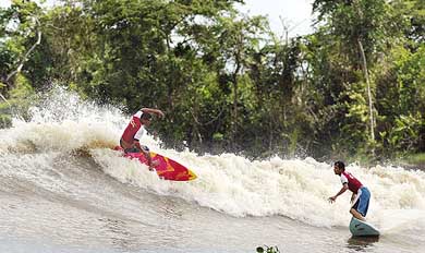 Brazilian surfers Savio Carneiro and Sandro Buguelo ride the thunderous "pororoca" tidal bore wave during the national "pororoca" circuit final 