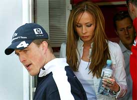 William's Formula One driver Ralf Schumacher of Germany is followed by his wife Cora and brother Michael Schumacher of Ferrari as they leave the San Marino Grand Prix in Imola