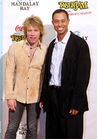 Star singer Jon Bon Jovi and ace golfer Tiger Woods pose for photographers 