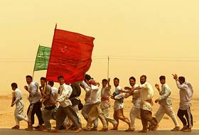 Iraqi Shiites carry religious flags as they make their way to the central city of Kerbala