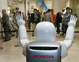 Customers watch as Honda Motor Co's humanoid robot Asimo makes its debut 