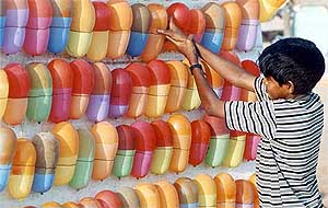 Balloon vendor Siva Kumar, 11, adjusts balloons at a beach