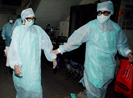 Two members of the same family diagnosed with suffering from the SARS virus walk to the ambulance