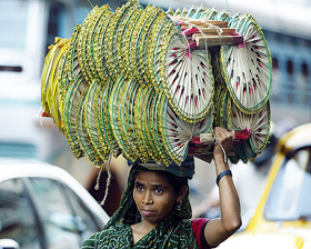 A woman carries hand fans