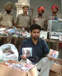 The accused sits with prepared VCDs and other equipments