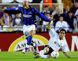 Inter Milan's Stephane Dalmat is tackled by Valencia's Vicente 