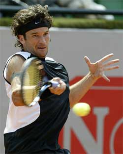 Carlos Moya of Spain returns a shot against Adrian Voinea of Romania 