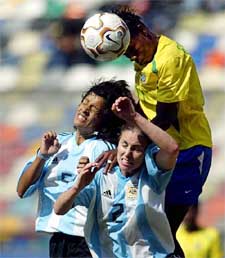 Formiga of Brazil heads the ball as Argentina's Gerez and Clarisa Huber try to stop her