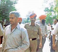 A cop, accused in a police-criminal nexus, being taken to court 