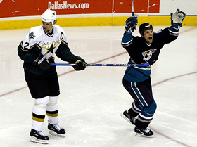 Anaheim Mighty Ducks' left winger Mike Leclerc celebrates while Dallas Stars' defender Derian Hatcher looks back at the goal after Ducks' Petr Sykora scored