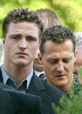 Formula one drivers Ralf and Michael Schumacher walk behind the coffin of their mother