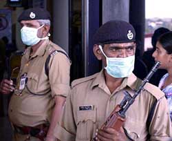 Securitymen wearing mask to protect themselves from the SARS virus stand outside Panaji airport