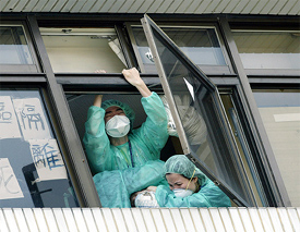 A Taiwanese woman, who had been quarantined for SARS, tried to throw herself out of a window at a Taipei hospital is pulled back inside 