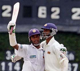 Sri Lankan captain Hashan Tillakaratne is embraced by team-mate Kumara Dharmasena after Tillakaratne reached his 100