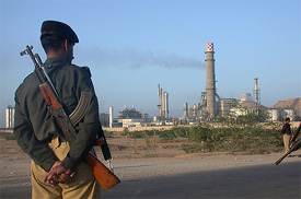A Pakistani policeman stands guard outside the Fauji-Jordan Fertiliser plant