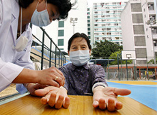 An elderly woman wearing a face mask receives free treatment 