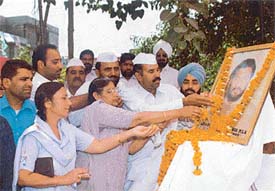 Mr Sushil Parashar, coordinator, Congress Seva Dal, and other Congress activists offer flowers at the portrait of Sat Pal Parashar
