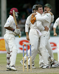 Australian spinner Stuart McGill is embraced by teammate Adam Gilchrist after the former dismissed Ramnaresh Sarwan 