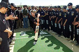 Colonel Mark Theobald, commander of the British forces, plays a shot to inaugurate a friendly cricket match