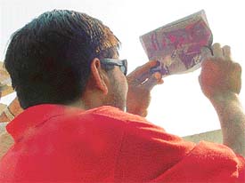 A star gazer tries to behold the transit of Mercury through a film negative