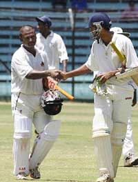 Mumbai captain Paras Mahambarey congratulates off spinner Ramesh Pawar 