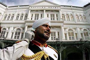 Doorman of Raffles Hotel Sarjit Singh gets his temperature checked