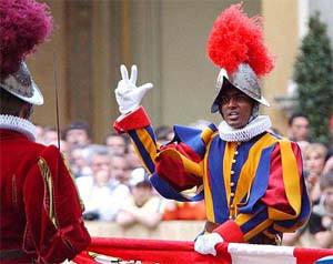 New recruit Dhani Bachmann, of Indian origin, raises three fingers in allegiance to Pope John Paul II