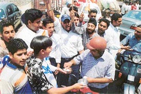 Activists of the Akhil Bharatiya Vidyarthi Parishad beg on the streets of Ludhiana on Thursday to raise money for paying their college fees