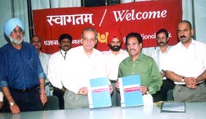 SAI executive director C R Gopnath (right) and PNB general manager P. N. Khurana display the MoU after the signing ceremony in the presence of former Olympian Ajit Pal Singh at the Jawaharlal Nehru Stadium on Friday.