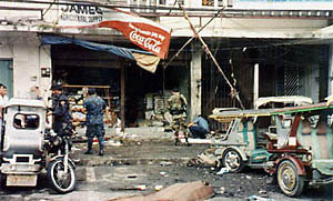 The police surveys the site of a bomb explosion in the southern Philippine town of Koronadal 