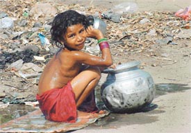 Beating the heat: A child plays with water as mercury soars in the region