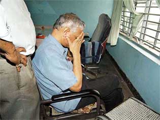 harkhand government's Commissioner of Road Construction Ashok Kumar Singh, an IAS officer involved in Bihar Financial Corporation scam, covers his face