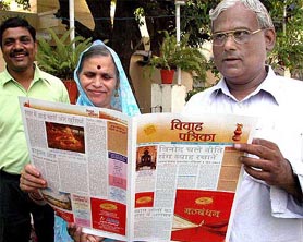 An owner of an advertising agency displays a 4-page invitation card for his son's marriage in Bhopal