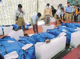 Volunteers place ice slabs around the bodies of the victims of the train mishap